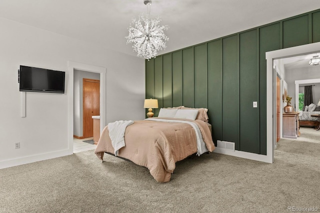 carpeted bedroom featuring connected bathroom and a notable chandelier