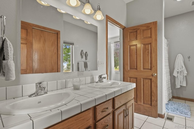 bathroom with vanity, a wealth of natural light, and tile patterned floors