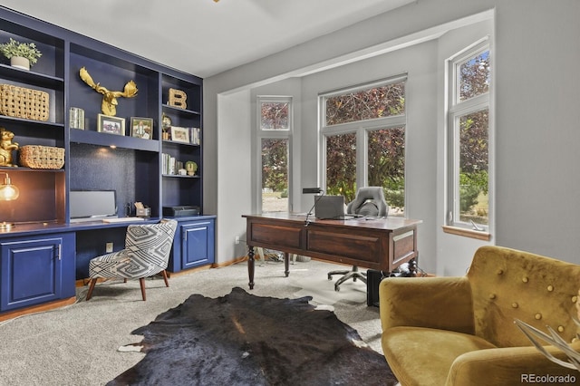 carpeted office featuring built in shelves and built in desk