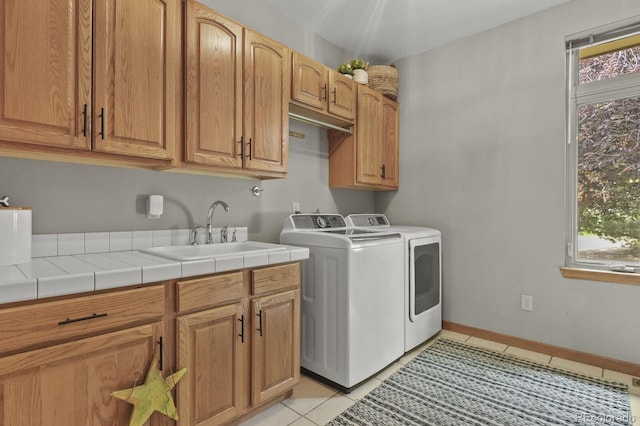 washroom with cabinets, a healthy amount of sunlight, sink, and light tile patterned floors