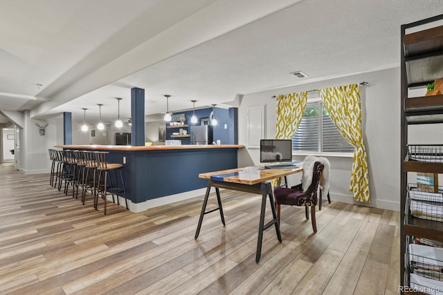 home office featuring bar area and light hardwood / wood-style flooring