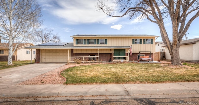 split foyer home featuring an attached garage, brick siding, a front lawn, and a porch