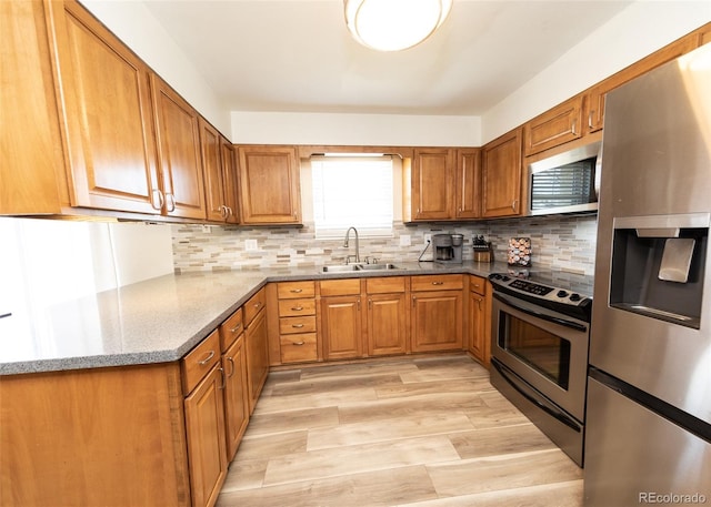 kitchen featuring a sink, brown cabinets, and stainless steel appliances