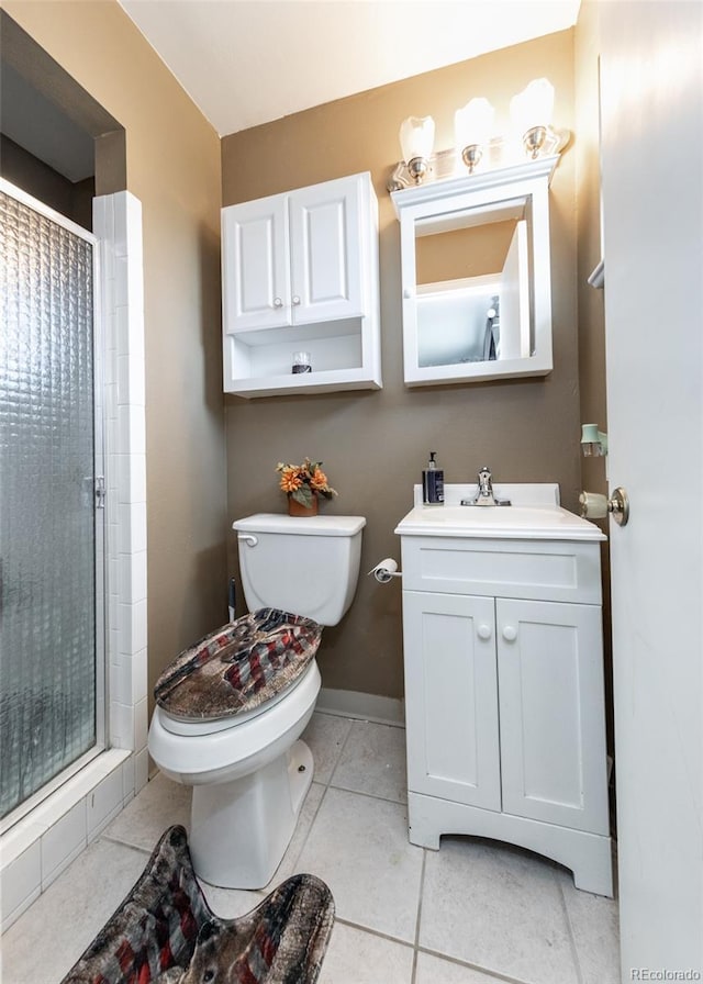 bathroom featuring tile patterned floors, toilet, a shower stall, and vanity