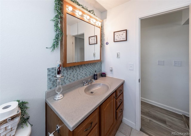 bathroom with backsplash, baseboards, and vanity