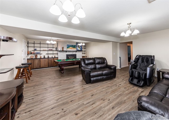 living room with a chandelier, wood finished floors, and billiards