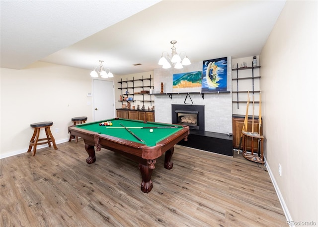 playroom with baseboards, billiards, a chandelier, a fireplace, and wood finished floors