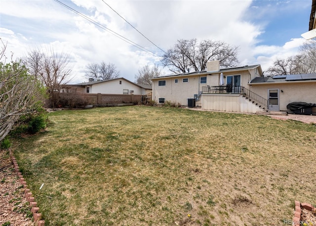 view of yard featuring a wooden deck, fence, and stairway