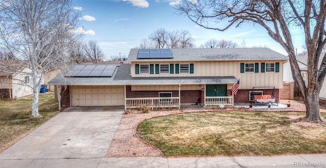 bi-level home with brick siding, a shingled roof, and driveway