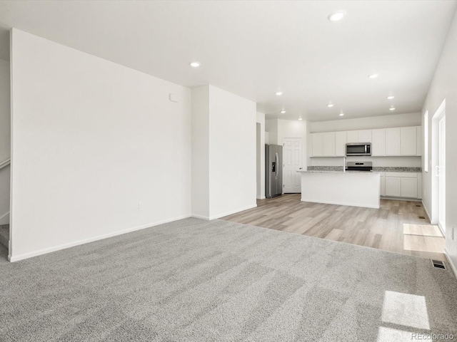 4694 Sugarcane St, Johnstown, CO 80534 - unfurnished living room with light colored carpet and recessed lighting
