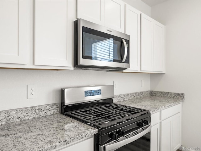 4694 Sugarcane St, Johnstown, CO 80534 - kitchen with stainless steel appliances, white cabinets, and light stone countertops