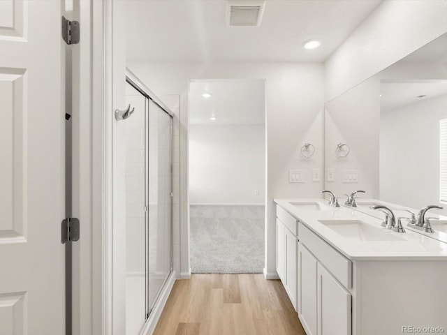 4694 Sugarcane St, Johnstown, CO 80534 - full bathroom featuring wood finished floors, a stall shower, double vanity, and recessed lighting