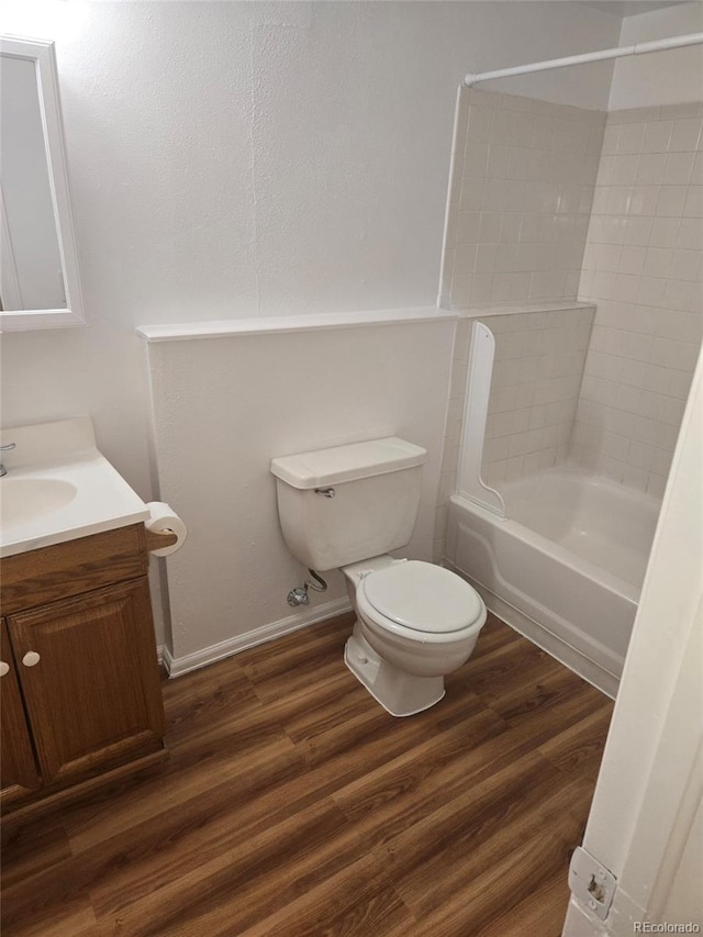 full bathroom with tiled shower / bath combo, hardwood / wood-style flooring, vanity, and toilet