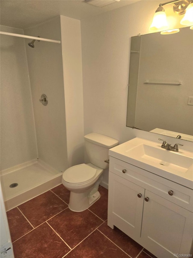 bathroom with vanity, a shower, tile patterned flooring, and toilet