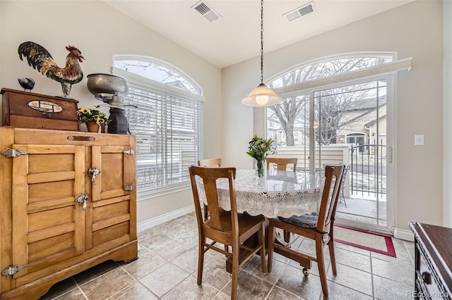 dining area featuring vaulted ceiling, visible vents, and baseboards