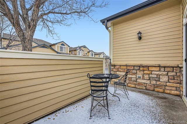 snow covered back of property featuring a patio