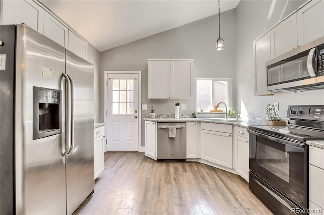 kitchen with white cabinetry, appliances with stainless steel finishes, light hardwood / wood-style floors, and pendant lighting