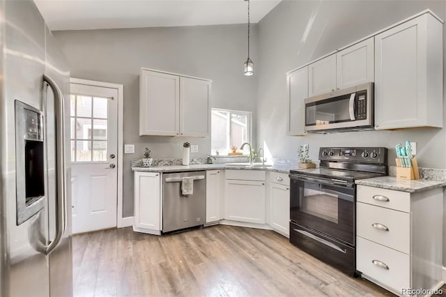 kitchen with white cabinetry, sink, stainless steel appliances, and lofted ceiling