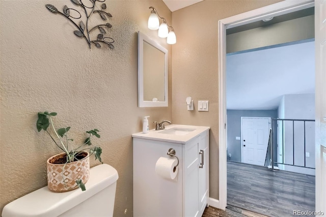 bathroom featuring hardwood / wood-style flooring, vanity, and toilet