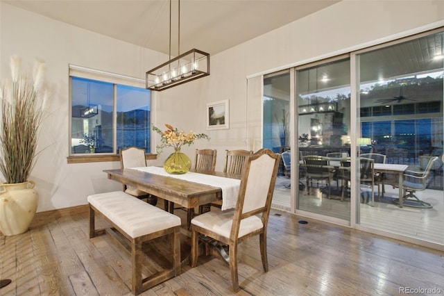 dining area featuring hardwood / wood-style floors and an inviting chandelier