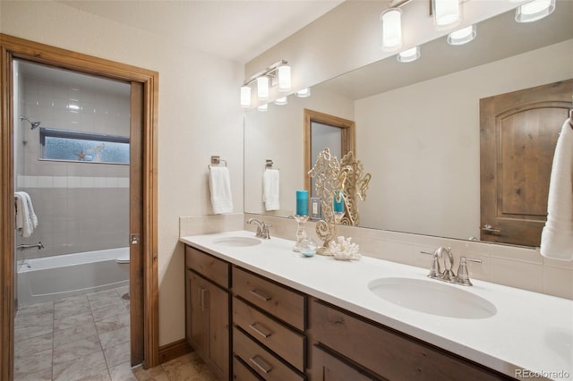 bathroom featuring tiled shower / bath, backsplash, and vanity