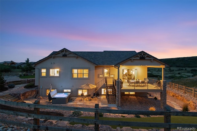 back house at dusk with a patio area and a deck