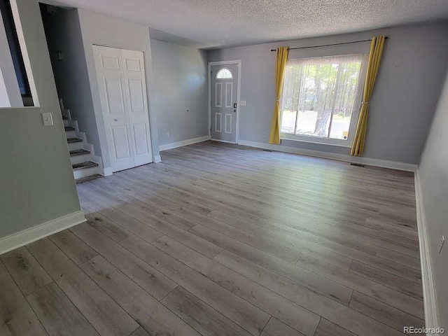 spare room featuring wood-type flooring and a textured ceiling