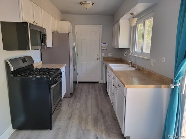 kitchen featuring white cabinetry, stainless steel appliances, light hardwood / wood-style flooring, and sink