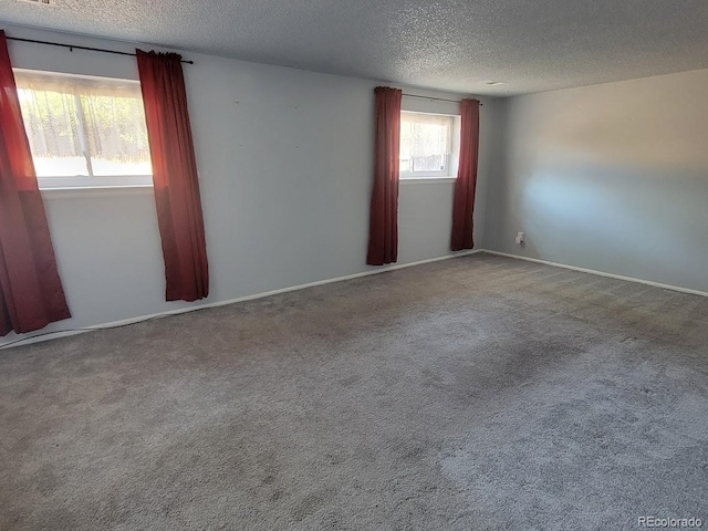 carpeted spare room with a textured ceiling