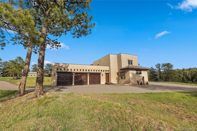 28098 Green Valley Ln, Conifer, CO 80433 - view of front facade featuring a garage, stucco siding, driveway, and a front yard