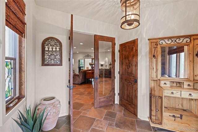 28098 Green Valley Ln, Conifer, CO 80433 - hallway featuring healthy amount of natural light and stone tile flooring
