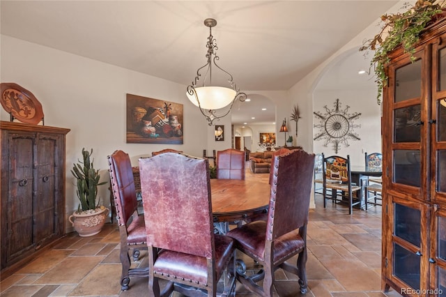 28098 Green Valley Ln, Conifer, CO 80433 - dining area featuring stone tile flooring, arched walkways, and recessed lighting