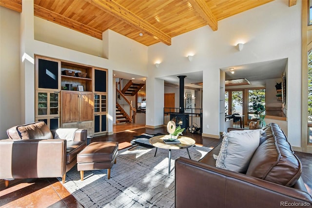 9041 Eastridge Rd, Golden, CO 80403 - living area featuring wooden ceiling with exposed beams, a wood stove, stairway, and a high ceiling