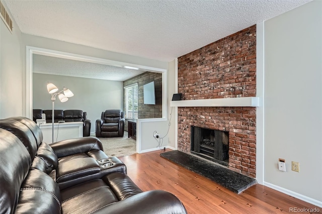 9630 W 104th Ave, Broomfield, CO 80021 - living area featuring wood finished floors, a textured ceiling, and a fireplace