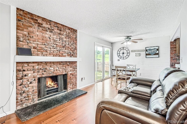 9630 W 104th Ave, Broomfield, CO 80021 - living room featuring a textured ceiling, a ceiling fan, wood finished floors, and a brick fireplace