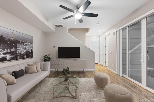 living room featuring ceiling fan and hardwood / wood-style floors