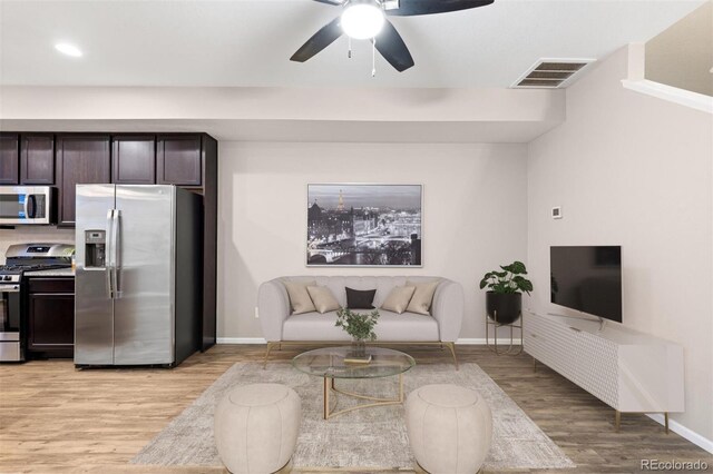 living room with ceiling fan and light hardwood / wood-style floors