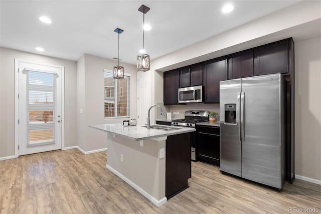 23630 E 5th Pl, Aurora, CO 80018 - kitchen with stainless steel appliances, light wood finished floors, a kitchen island with sink, pendant lighting, and recessed lighting