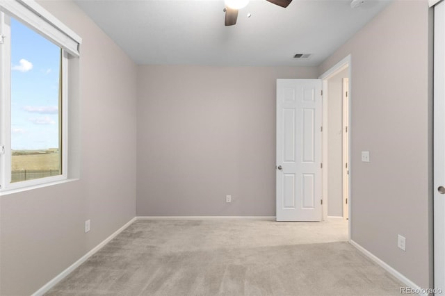 unfurnished room with ceiling fan and light carpet