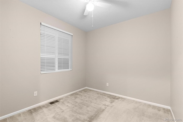 spare room with ceiling fan and light colored carpet