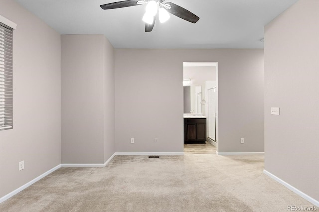 spare room with ceiling fan and light colored carpet