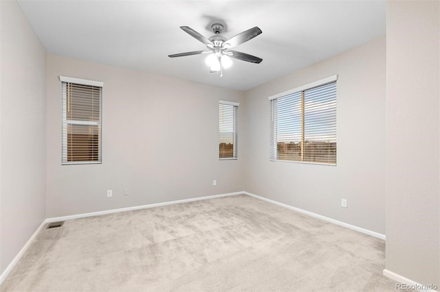 empty room featuring ceiling fan and light colored carpet