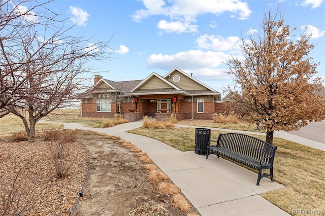 23630 E 5th Pl, Aurora, CO 80018 - view of front of property featuring a porch, brick siding, a front yard, and a chimney