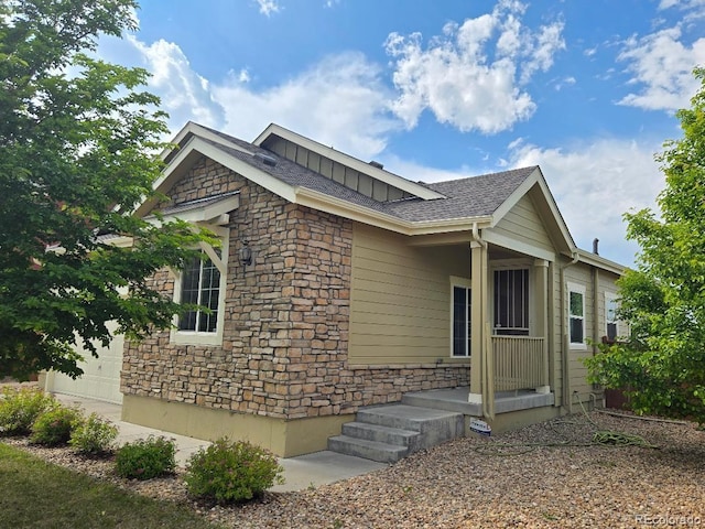 483 W 172nd Pl, Broomfield, CO 80023 - view of property exterior with stone siding, an attached garage, board and batten siding, and a shingled roof