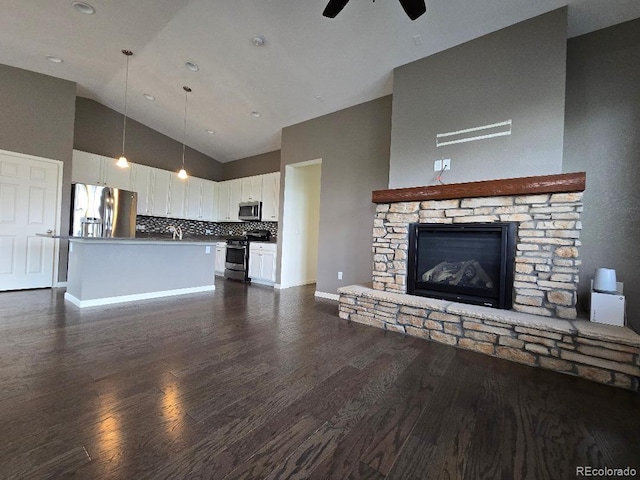 483 W 172nd Pl, Broomfield, CO 80023 - unfurnished living room featuring ceiling fan, dark wood finished floors, high vaulted ceiling, a stone fireplace, and baseboards