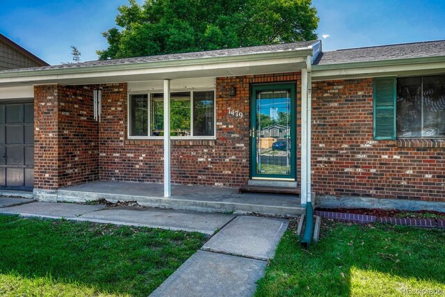 7479 Pierce St, Arvada, CO 80003 - view of exterior entry featuring brick siding and covered porch