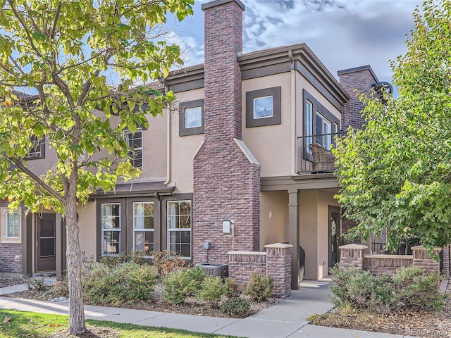 view of property featuring cooling unit and stucco siding