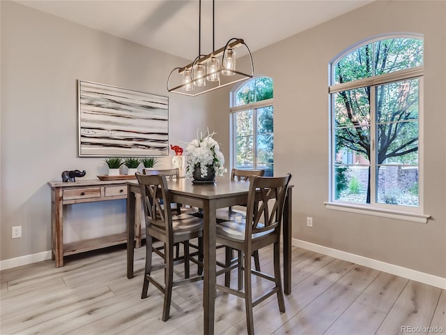 dining area featuring light wood-style flooring and baseboards