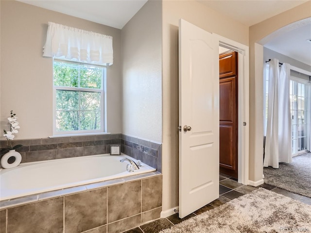 full bath featuring a bath and tile patterned floors