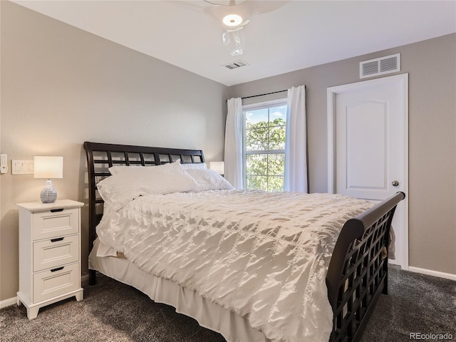 bedroom with dark carpet, visible vents, and baseboards